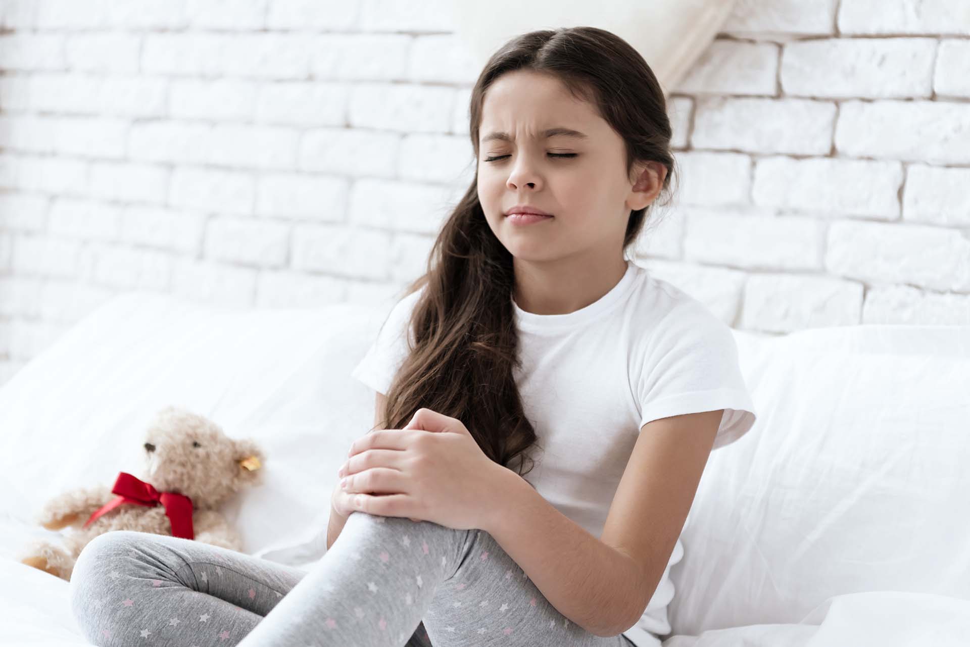 Small girl hold knee in pain
